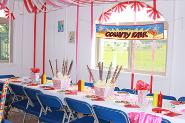 Room decorated for a party. Sign reads county fair.