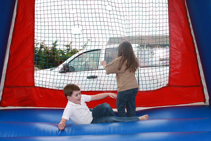 Emerald dolphin's bounce house photo of 2 children playing in the bounce house at Emerald Dolphins / Ed's Mini golf and arcade.