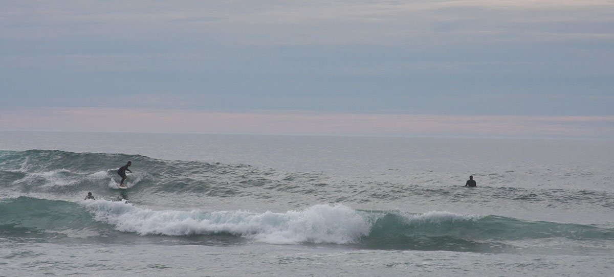 photo shows surfers on the Pacific Ocean on the Mendocino Coast.