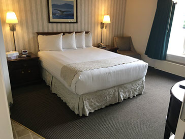 Photo showing queen bed,end tables with lamps.