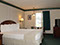 Our King Suite showing a European King bed, table with 2 chairs, dresser, night stands and large window.