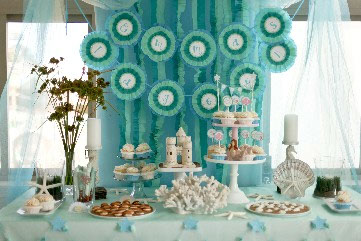 photo of a beautiful display of soft blue pastels, cupcakes and decorations.
