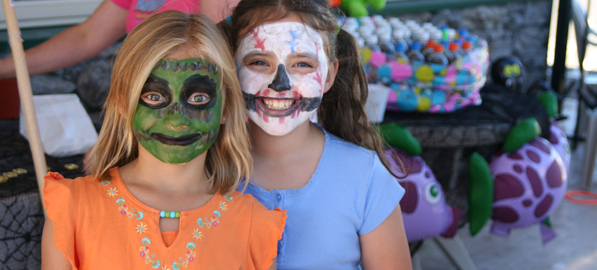 photo of 2 girls with painted faces at a special event for halloween.