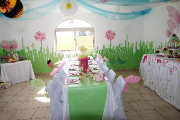 photo shows party room decorated in soft pastels of green, blue and pink. Has decorations with pink flowers and butterflys.