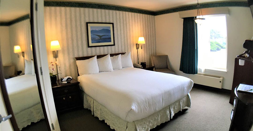 Photo showing our accessible queen room with a queen size bed with 2 night stands, lamps, alarm clock and direct dial phone.